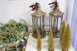 Na casa, árvores de Natal estão presentes na decoração em diferentes cores e tamanhos.