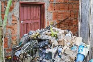 Montanha de lixo cobre quase metade da porta da casa (Foto: Henrique Kawaminami)