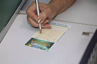 Apostadora de Campo Grande preenche volante em agência lotérica. (Foto: Arquivo/Marcos Maluf)
