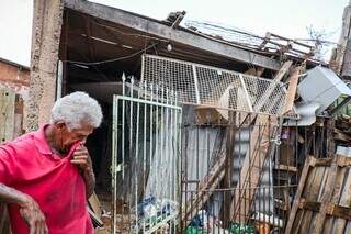 Ademar parado em frente a casa onde acumula entulhos, no Jardim Centro-Oeste (Foto: Henrique Kawaminami)