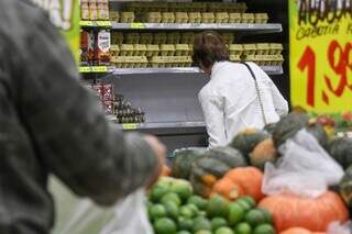 Consumidora olha preço de produtos na prateleira de supermercado (Foto: Henrique Kawaminami)
