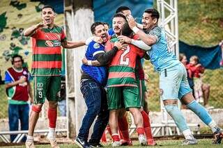 Glauber (de azul escuro) comemorando o título estadual com seus comandados (Foto: Vinicius Eduardo/@eduardofotoms)