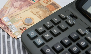 Consumidor calcula impostos em calculadora. (Foto: Marcello Casal Jr./Agência Brasil)