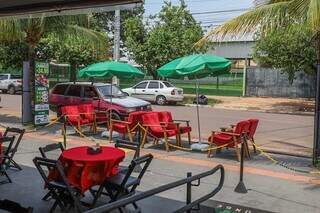 Calçada de restaurante onde Hugson trabalha; estabelecimento ocupa boa parte com mesas e cadeiras e área de espera (Foto: Henrique Kawaminami)