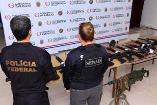 Agentes da Senad e da PF brasileira ao lado de armamento; no chão, a metralhadora antiaérea (Foto: Divulgação)