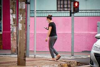 Mulher mexendo no celular enquanto anda pelo Centro de Campoo Grande (Foto: Henrique Kawaminami/Arquivo)