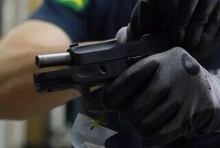 Policial manipula uma pistola. (Foto: Diego Vara/Agência Brasil)