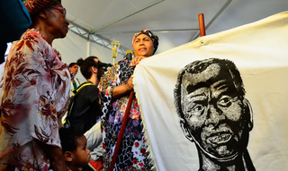 Manifestante segura pintura feita a mão com rosto de Zumbi dos Palmares. (Foto: Rovena Rosa/Agência Brasil)