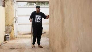 Leandro usa um cabo de vassoura como bengala improvisada para se locomover em casa (Foto: Alex Machado)