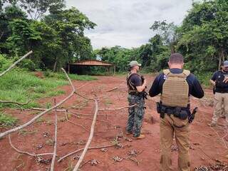 Agentes paraguaios em frente a uma das bases identificadas em uma área rural de Corpus Christi, no Paraguai (Foto: Divulgação)