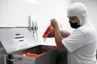 Funcionário de açougue produzindo linguiça dentro da própria empresa que é fiscalizada pela Sidagro (Foto: PMCG)