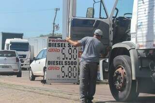 Wilson Perez limpando porta do caminhão da empresa onde trabalha (Foto: Marcos Maluf)
