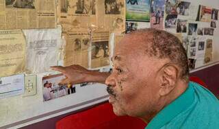 Michel, 88 anos, mostra um pedaço da história que colou na parede de casa (Foto: Marcos Maluf)