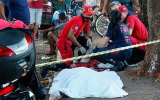 Corpo do idoso coberto por lençol no local onde caiu e morreu (Foto: Alex Machado)