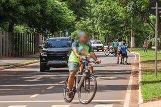 Pai leva filho em bicicleta dividindo espaço com veículos. (Foto: Henrique Kawaminami)