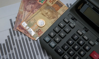 Consumidor usa calculadora para cuidar de gastos excessivos. (Foto: Marcello Casal Jr./Agência Brasil)