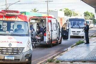 Idoso sendo socorrido pela equipe do Samu; micro-ônibus ao fundo, com policial militar próximo ao veículo (Foto: Henrique Kawaminami)