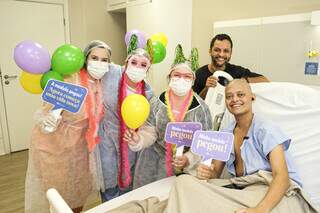 Sentado na maca do Hospital da Cassems, Kauan celebra o sucesso do transplante de medula com equipe multidisciplinar (Foto: Cassems)