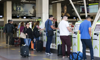 Passageiros são atendidos em guichês eletrônicos em aeroporto. (Foto: Antonio Cruz/Agência Brasil)
