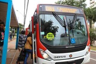 Passageiros embarcam em ônibus, em Campo Grande. (Foto: Alex Machado)