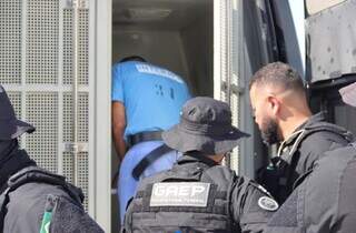 Marcinho VP entrando em camburão escoltado por policiais penais federais durante transferência (Foto: Senappen/Divulgação)