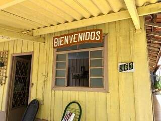 Placa de madeira &#39;Bienvenidos&#39; está pendurada na frente da casa. (Foto: Jéssica Fernandes)