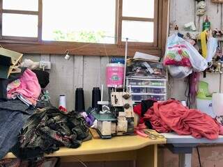 Tecidos e outros acessórios de costura cobrem a mesa. (Foto: Jéssica Fernandes)