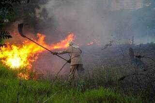 Bombeiro tenta controlar fogo com abafador (Foto: Juliano Almeida)