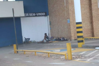 Moradores de rua deitados em frente à entrada de mercado desativado em Campo Grande. (Foto: Arquivo/Alex Machado)