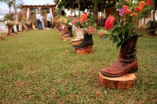 Pares de botas com arranjos de flores foram colocados no caminho para altar. (Foto: @wesleybrunafotografia)