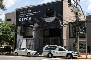 Carro da funerária em frente à delegacia de polícia. (Foto: Henrique Kawaminami)