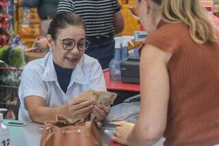 Marlei contando várias notas de R$ 50, entregue por consumidora durante compra no supermercado (Foto: Marcos Maluf)