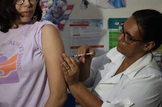 Adolescente sendo imunizada contra a dengue em Dourados (Foto: Marcos Adriano/Assecom)