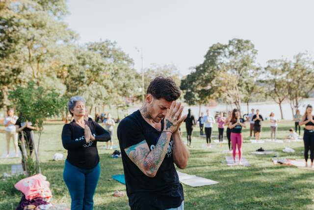 Com roda de mantras e &aacute;gua de coco, grupo realiza aula de yoga no parque