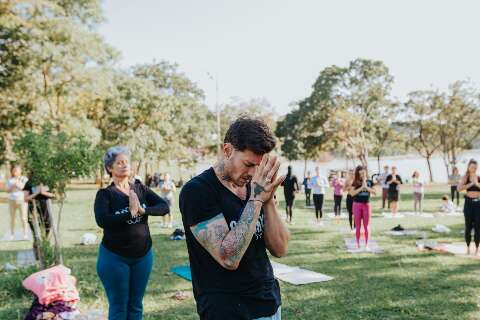 Com roda de mantras e água de coco, grupo realiza aula de yoga no parque