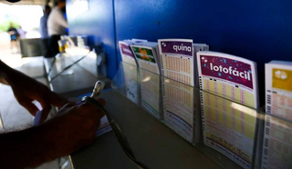 Apostador preenche volantes de loteria em agência lotérica. (Foto: Marcello Casal Jr./Agência Brasil)