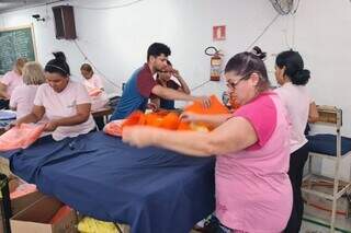 Mulheres trabalham confeccionando e empacotando roupas (Foto: Divulgação/Fiems)