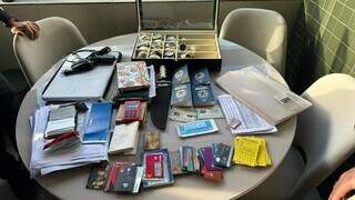 Cartões, passaportes e relógios apreendidos em operação. (Foto: Divulgação)