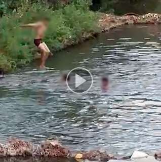 Crianças tomam banho animadas em rio, no vai e vem da Ernesto Geisel  
