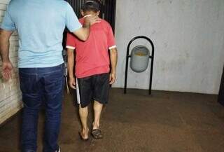 Suspeito chegando na delegacia onde o caso foi registrado (Foto: Osvaldo Duarte | Dourados News)