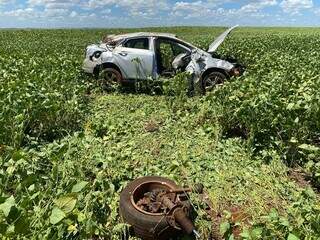 Roda e veículo em meio à planatação de soja após capotagem (Foto: A Gazeta News)