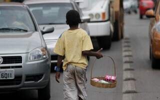 Menino vendendo balas e doces em meio ao trânsito de veículos (Foto: Reprodução)