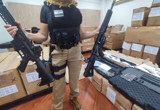 Agente da Senad mostra armas apreendidas no dia da operação, em dezembro (Foto: Divulgação)