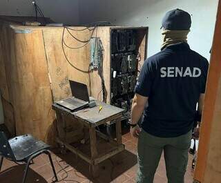 Agente da Senad em local onde funciona mineradora clandestina de criptomoeda (Foto: Divulgação)