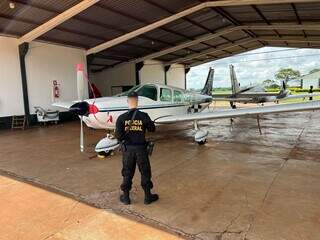 Agente da PF ao lado do avião de Aparecido Mendes; aeronave foi apreendida em dezembro (Foto: Arquivo)