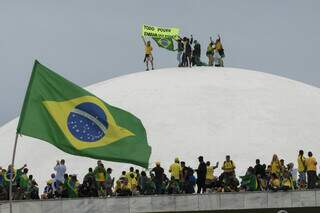 Bolsonaristas invadiram prédios públicos na praça dos Três Poderes, em 8 de janeiro de 2023; na foto, manifestantes sobre a cúpula do Senado Federal (Foto: Joedson Alves/Agencia Brasil)