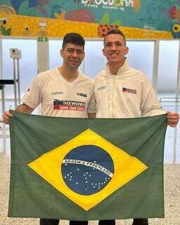 Técnico Fábio Costa e atleta Luiz Felipe Aquino com a bandeira do Brasil no Aeroporto de Campo Grande (Foto: Divulgação) 
