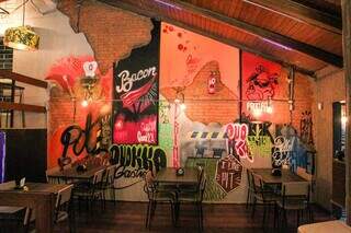 Na área interna, bar tem parede decorada com grafittes. (Foto: Juliano Almeida)
