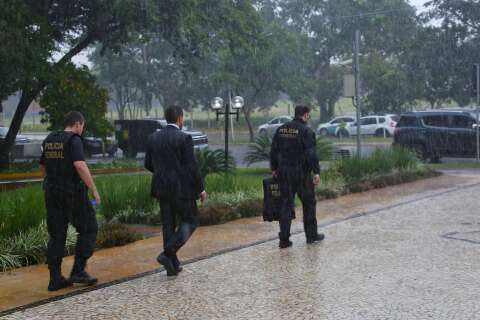 Após 3h30, PF sai do Tribunal de Justiça com dois malotes e debaixo de chuva