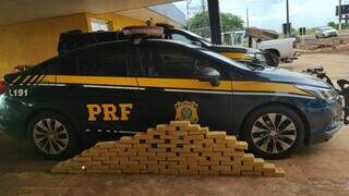 Tabletes de cocaína ao lado de viatura da PRF, hoje na BR-463 (Foto: Divulgação)